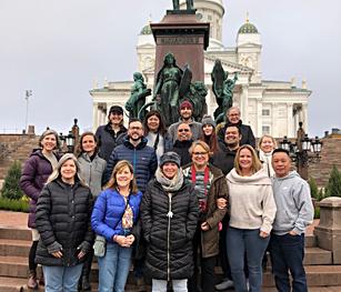 A group of teachers standing in front of a statue