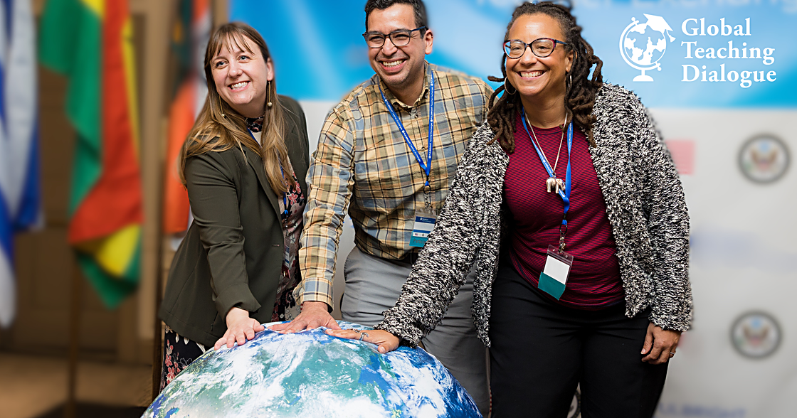 Three teachers standing in front of a globe